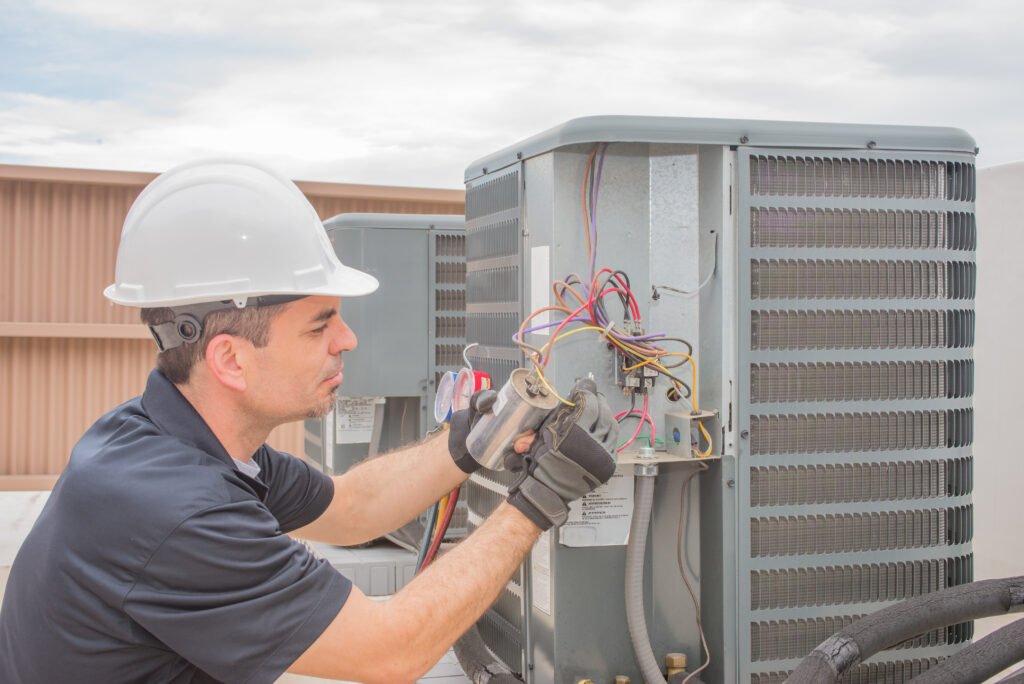 HVAC technician working on a capacitor part for condensing unit.